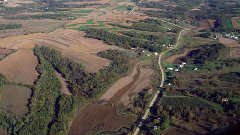 Aerial view of the Pecatonica watershed shows examples of contour farming between patches of wooded areas