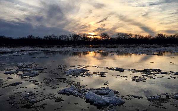 Ice melting on the Mississippi River at sunset