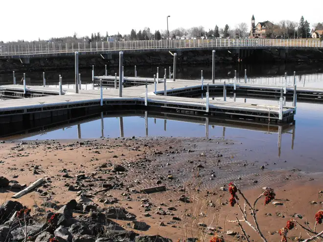Boat docks in very shallow water or resting on the lake bed due to extreme low lake levels.